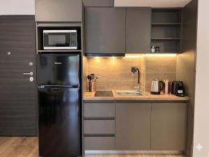 a kitchen with a black refrigerator and a sink at Lyda Apartment in Alexandroupoli