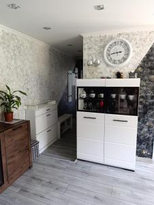 a kitchen with white cabinets and a clock on the wall at Rukiši in Saulkrasti