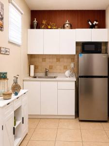 a kitchen with white cabinets and a stainless steel refrigerator at Los Flamboyanes Cozy Suite in Aguadilla