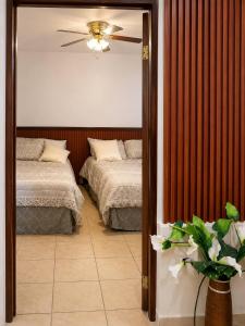 a bedroom with two beds and a mirror at Los Flamboyanes Cozy Suite in Aguadilla
