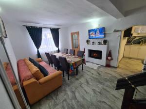 a living room with a table and a couch and a fireplace at Acasă la Cutuca in Ranca