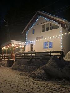 a house with christmas lights on the side of it at Acasă la Cutuca in Ranca