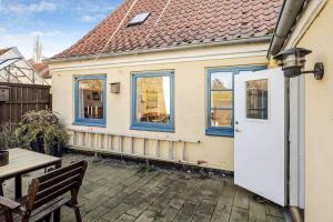 a small house with a white door and a table at AE330-Aeroskobing-Ostergade-8 in Ærøskøbing