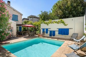a swimming pool with blue water in a yard at La Cerisaie in Lyon