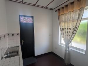 a bathroom with a black door and a window at AmeriLanka Transit Hotel in Seeduwa +31 photos