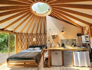 a room with a bed and a kitchen in a yurt at Ałabajka jurta i camping in Wleń