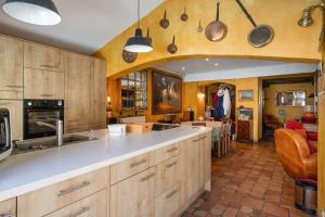 a large kitchen with wooden cabinets and a counter top at La Cerisaie in Lyon
