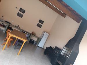 a kitchen with a table and chairs and a refrigerator at Casa com piscina e vista in São Pedro