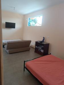 a bedroom with a bed and a television in it at Casa com piscina e vista in São Pedro