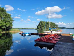 a group of boats docked at a dock on a lake at Przystań Narie in Kretowiny +18 photos