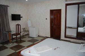 a bedroom with a bed and a tv in a room at Link Hotel in Lokossa