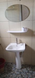 a bathroom with a white sink and a mirror at Link Hotel in Lokossa