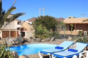 a swimming pool with two lounge chairs next to it at Canary House With Heated Pool in Tuineje