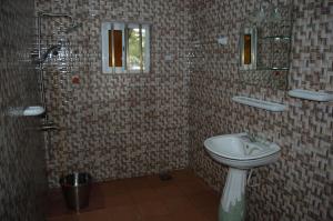 a bathroom with a sink and a shower and a toilet at Link Hotel in Lokossa