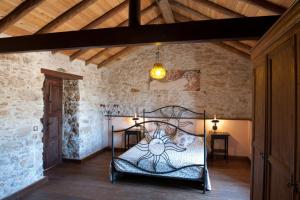 a bedroom with a iron bed in a stone wall at Canary House With Heated Pool in Tuineje +32 photos
