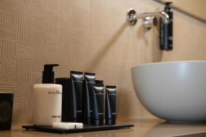 a bathroom counter with a sink and some products at Vivere Hotel in Catania +21 photos