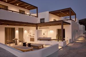 a large white house with a patio with tables at Ostraco Houses in Pachaina +34 photos
