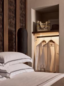 a bedroom with a bed and a shelf with clothes at Ostraco Houses in Pachaina