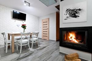 a dining room with a fireplace and a table and chairs at BIESZCZADZKI RAJ - DOM nad samym jeziorem, wysoki standard, basen, dostęp do wody, zielona plaża, motorówki, cisza i spokój in Olchowiec