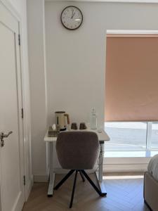 ein Schreibtisch mit Stuhl und Uhr an der Wand in der Unterkunft Double Ensuite Room, Bray in Bray
