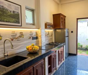 a kitchen with a bowl of fruit on a counter at Chami Leisure Home in Talpe