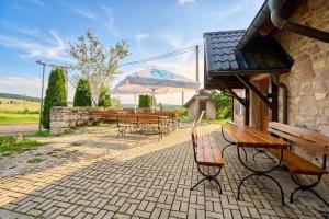 a patio with benches and an umbrella and tables at Lenhart's Ryžovna by Mountain ways in Boží Dar