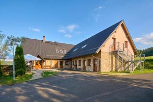 a large building with a black roof on a street at Lenhart's Ryžovna by Mountain ways in Boží Dar