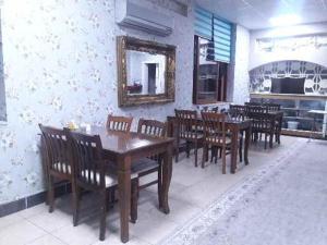 a dining room with wooden tables and chairs and a mirror at Yaşar otel in Mersin