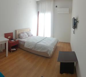 a bedroom with a bed and a table and a window at Yaşar otel in Mersin