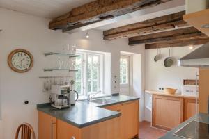 a kitchen with a sink and a clock on the wall at Ferienwohnung Blücherkate I - Boldevitzer Rügenkaten in Parchtitz