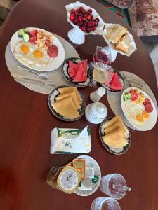 a table with plates of breakfast food on it at Green yard Guest house Barskoon in Barskoon +6 photos