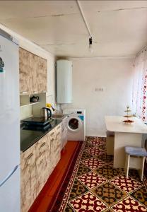 a kitchen with a washing machine and a table at "AlmUrUt" Guest House in Bokonbayevo