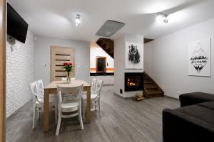 a dining room with a table and a fireplace at BIESZCZADZKI RAJ - DOM nad samym jeziorem, wysoki standard, basen, dostęp do wody, zielona plaża, motorówki, cisza i spokój in Olchowiec