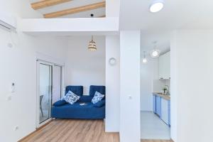 a living room with a blue couch and a kitchen at Wild Beauty in Sutomore