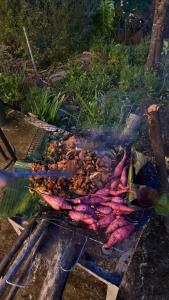 a bunch of meat cooking on a grill at The Bare Nest Retreat - Xóm Đung Homestay in Hòa Bình