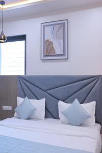 a bedroom with a large bed with white pillows at Hotel vs rooms in Ankleshwar