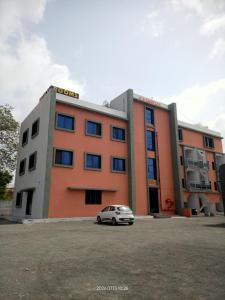 a car parked in front of a building at Hotel vs rooms in Ankleshwar