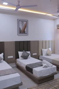 a hotel room with two beds in a room at Hotel vs rooms in Ankleshwar