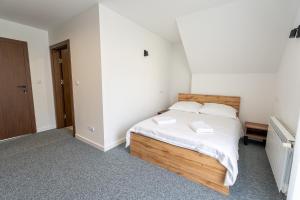 a bedroom with a bed with white sheets and pillows at Bieszczady Hill - Dolna in Czarna
