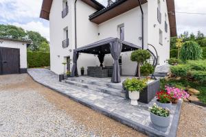 a white house with a porch with potted plants at Bieszczady Hill - Dolna in Czarna
