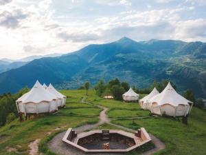 a group of tents on a hill with mountains at Glamping Tago in Khulo
