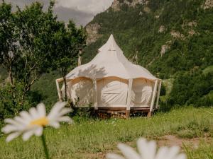 a large white tent in a field with flowers at Glamping Tago in Khulo +44 photos