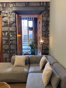 a living room with a couch and a stone wall at Hommage in Horta