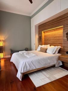 a bedroom with a large white bed with a wooden headboard at Hommage in Horta
