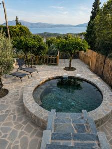a small pool in a patio with two chairs at Trigono Suites - Primavera  +12 photos