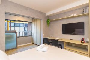 a room with a desk and a tv on a wall at Prime Exalt Ibirapuera in São Paulo