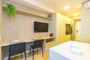 a living room with a table and chairs and a tv at Prime Exalt Ibirapuera in São Paulo