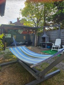 a blue hammock in a backyard with a grill at Pod Szklaną Wydmą - 2 min pieszo do plaży in Chłopy