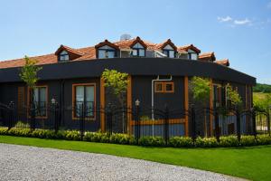 a black house with a fence in front of it at New Green Airport Hotel & Restaurant in Arnavutköy