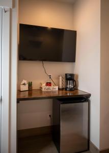 a desk with a coffee maker and a television on a wall at The Sand and Sage Suite in Page +8 photos